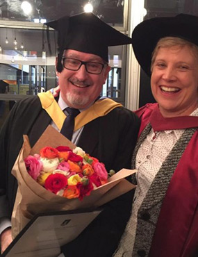 Professor Sheedy at a graduation holding flowers