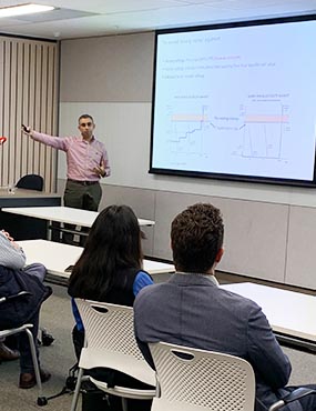 Man standing in front of a screen delivering a presentation