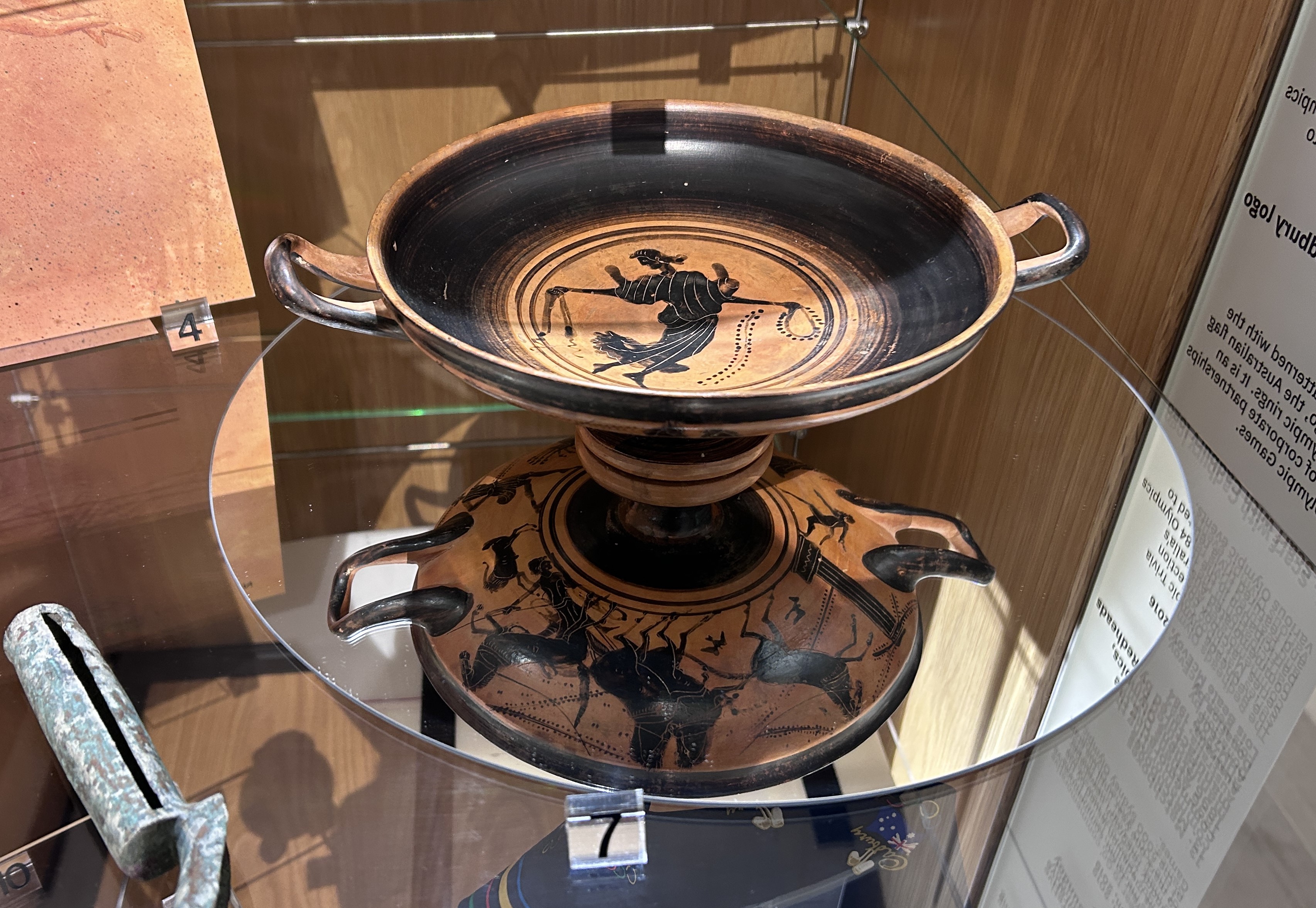 Image of black and brown vessel with chariot race