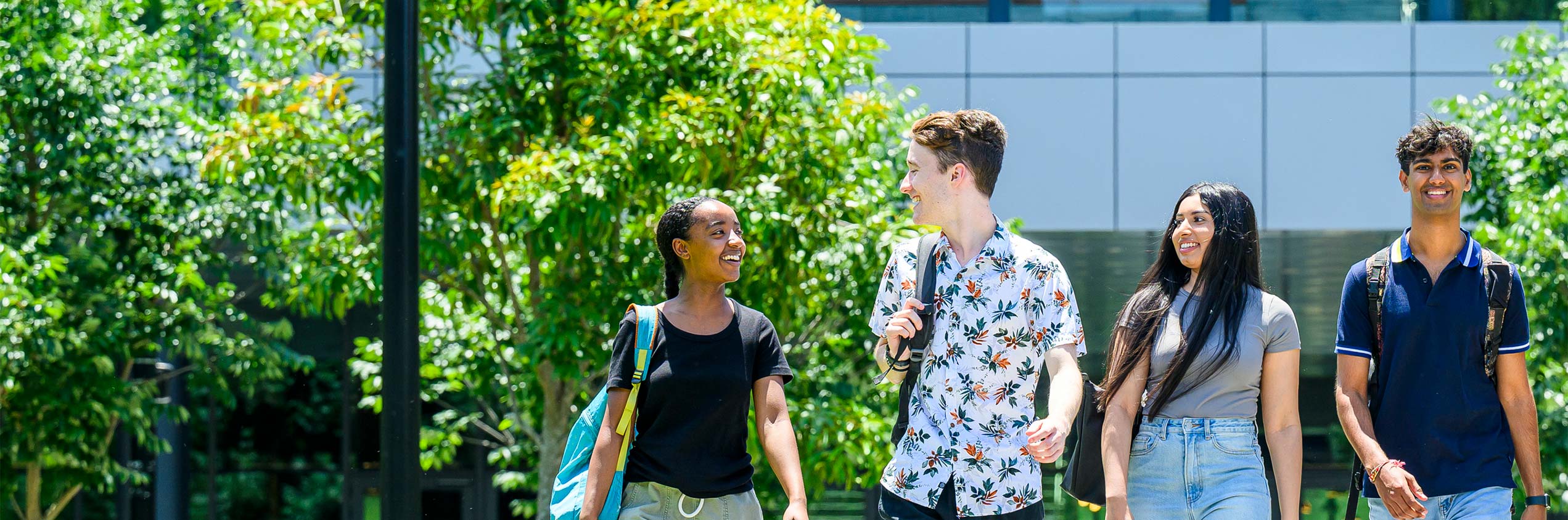 4 students walking down campus