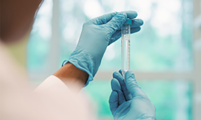 Hands of a scientist examining test tube