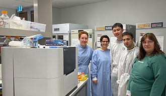 People standing around the BioCellX machine in a lab