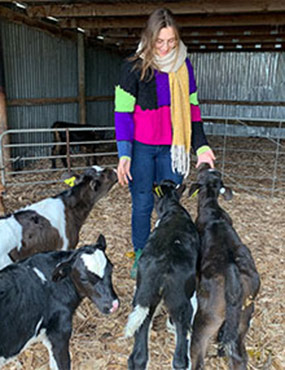 Milena Bojovic in a barn with four calves.