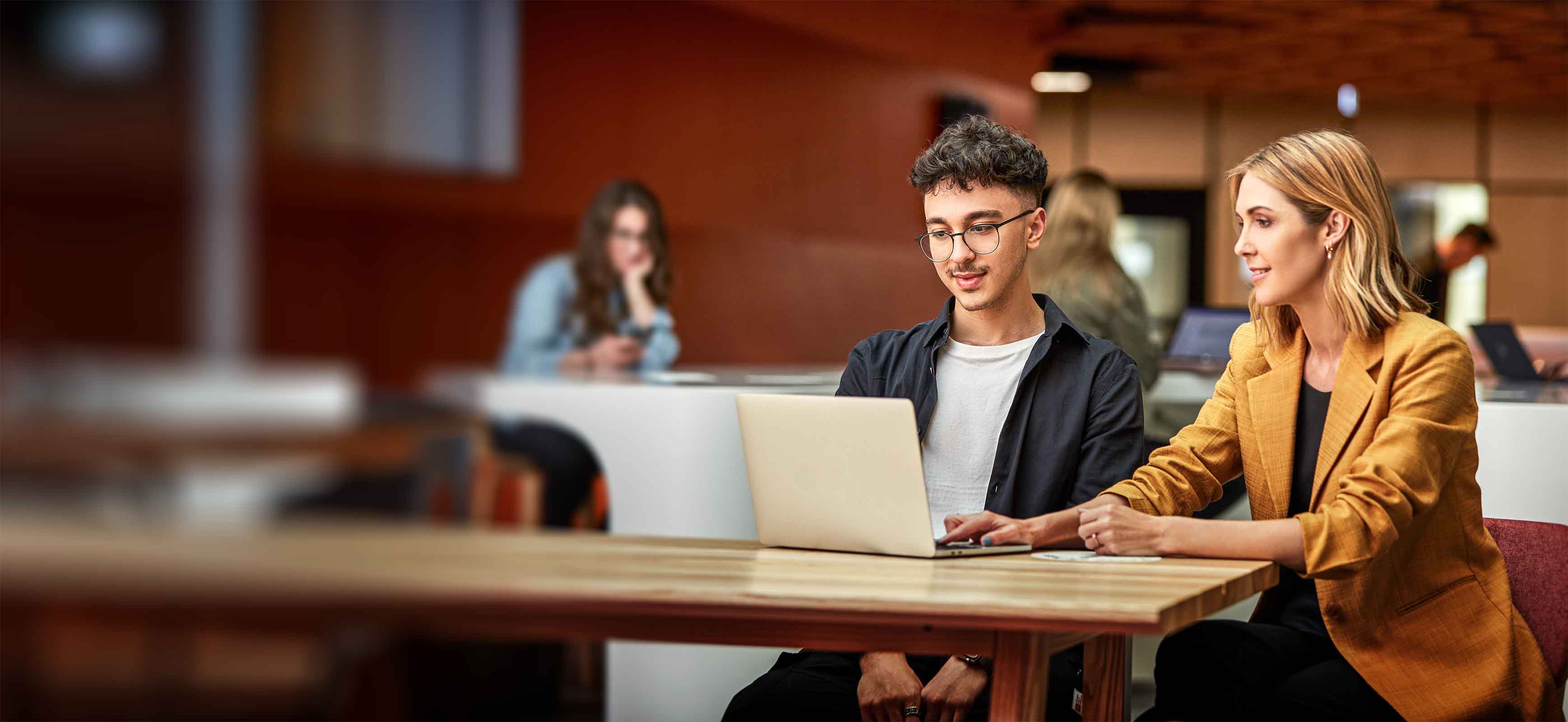 2 students in the library looking at a computer