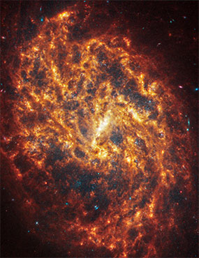 Face-on spiral galaxy, NGC 1087, split diagonally, showing an inverse of darkness and light.