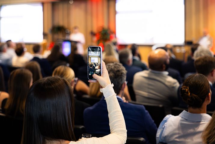 Someone taking a photo of someone presenting at an event.