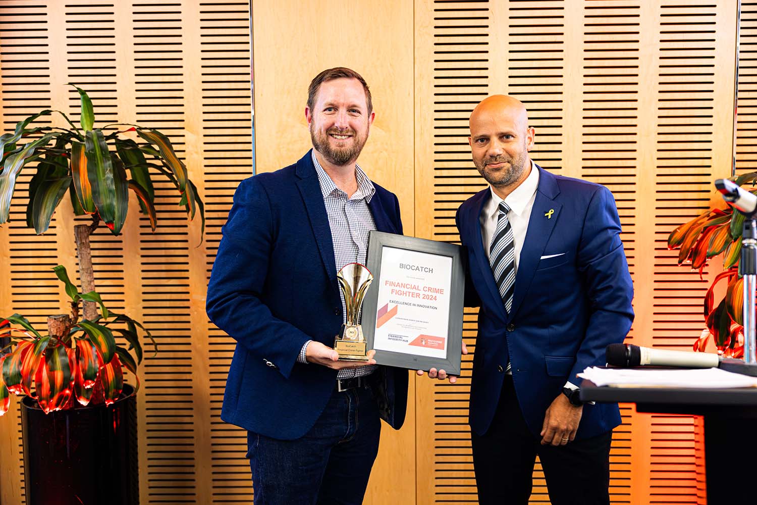 An award winner being presented a certificate and trophy.