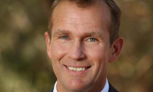 Headshot of Rob Stokes wearing a suit and smiling.