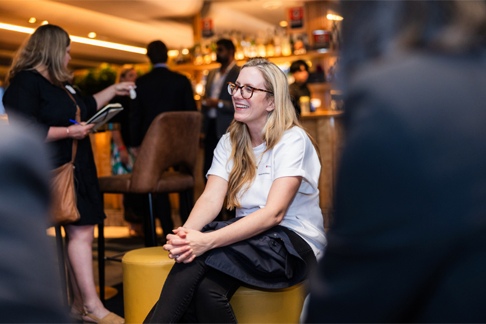 Lady sitting in conversation with others at the Beer with the Boss event