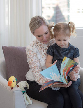 Cara with a child reading a book