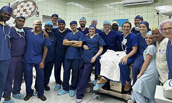 Group of surgeons and nurses involved in the operation, standing together in the theatre