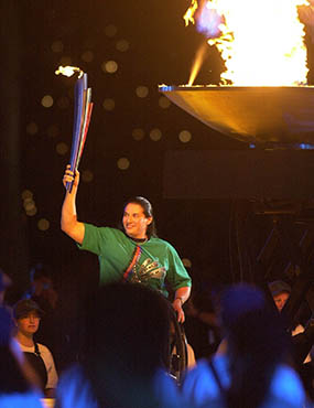 A wheelchair athelete lighting the Olympic flame