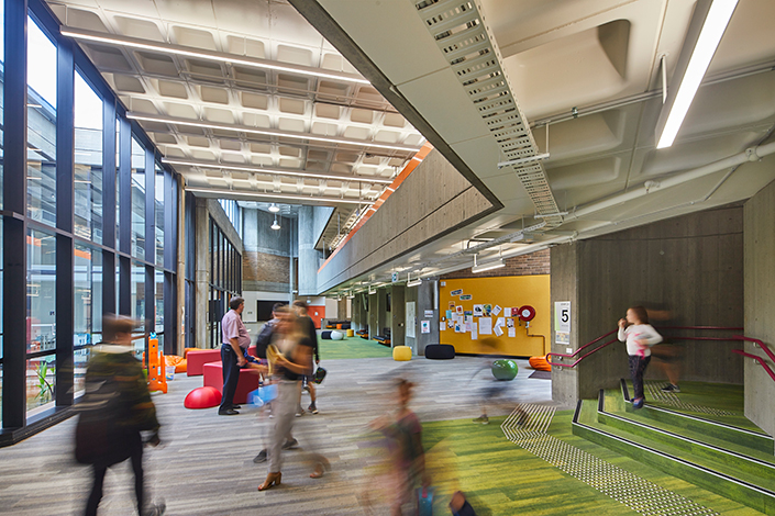 An image of people walking through an indoor schoolike building with a blurry after effect