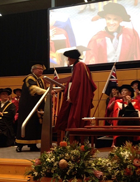 Josh Kidd graduating, shaking Michael Egans hand