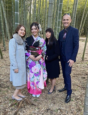 Josh Kidd standing with his family for a photo infront of bamboo trees