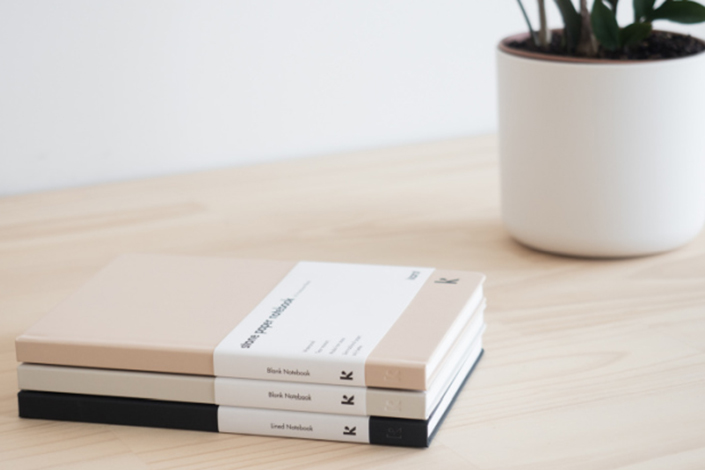 Stack of three books with a white pot plant sitting close behind it