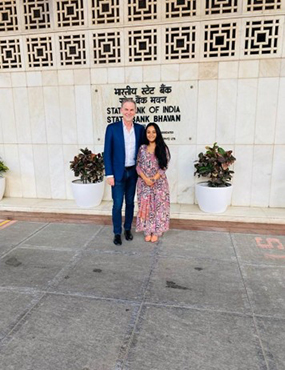 Gunjan posing for a photo outside a building with a man by her side