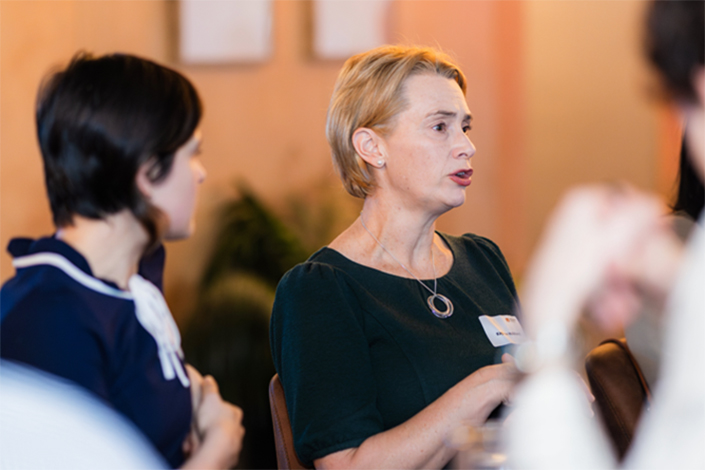 Lady in a black dress talking at the Beer with a Boss event