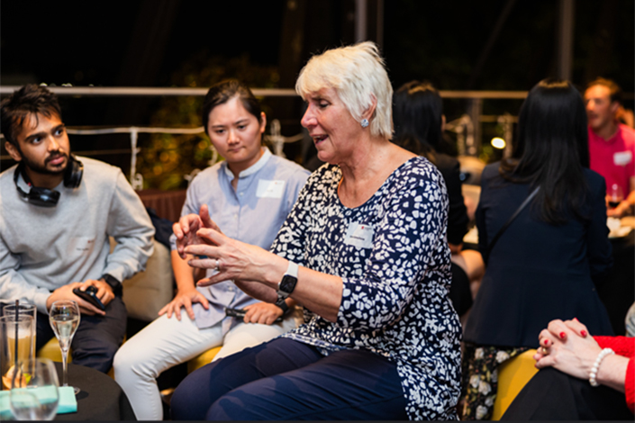 Older lady talking to a group at the Beer with a Boss event