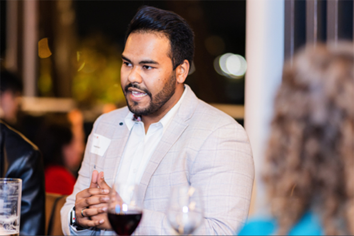 Man in a grey suit talking to a group at the Beer with a Boss event